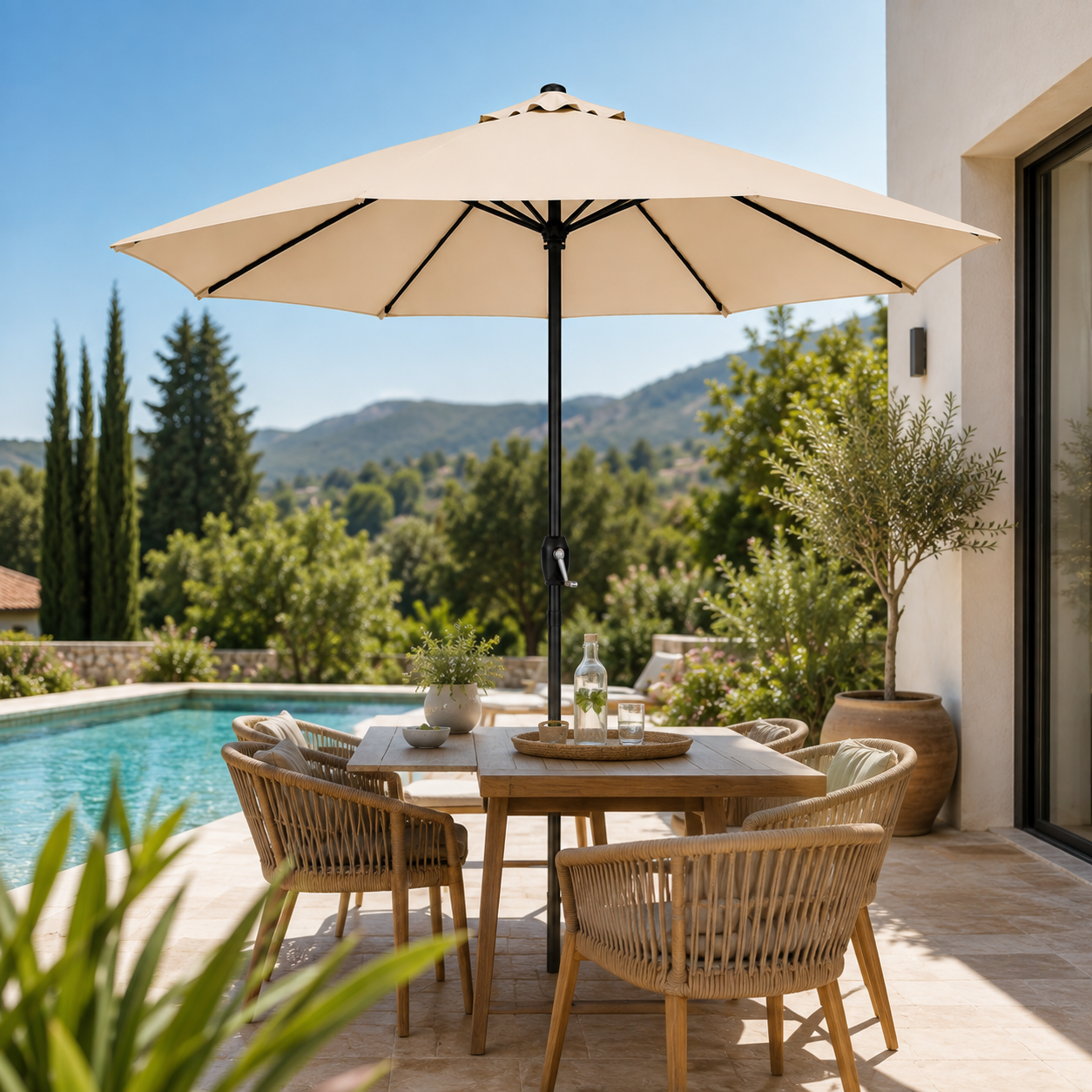 Una mesa de patio de madera con sillas y sombrilla junto a una piscina, con árboles verdes.