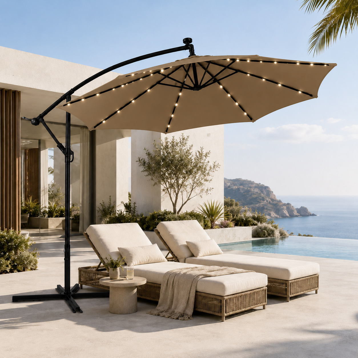 Una sombrilla de patio beige con luces cubre dos tumbonas junto a la piscina con vistas al mar.