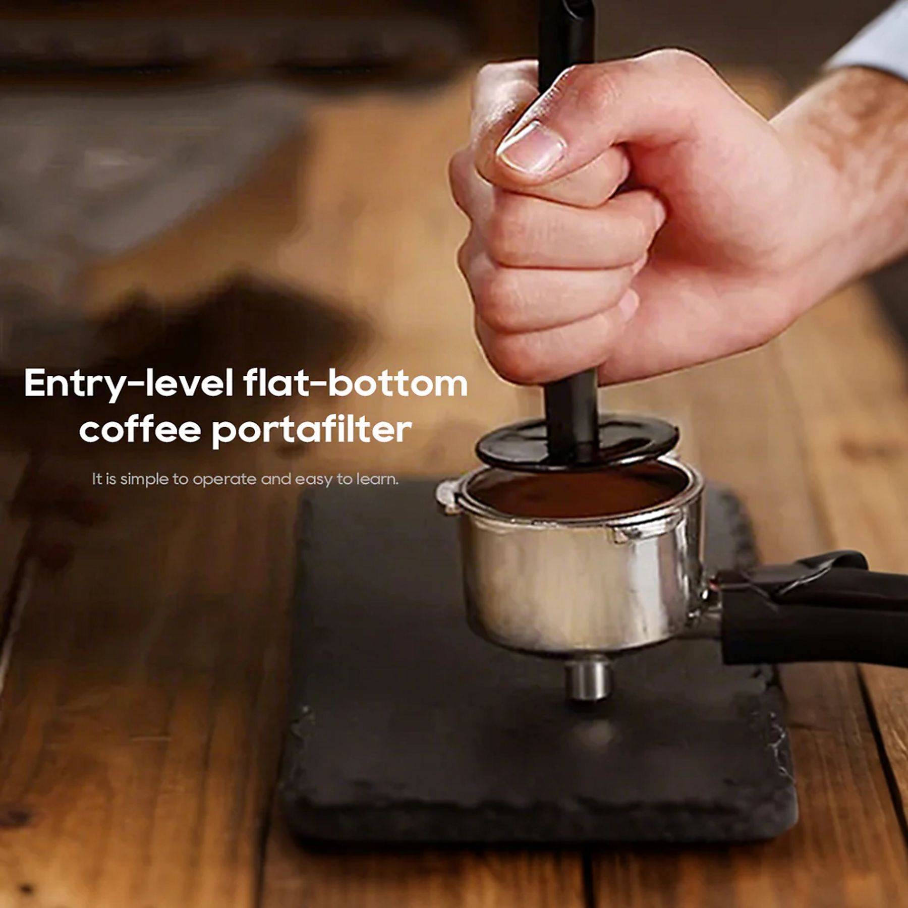 Eine Hand drückt einen Tamper in einen Kaffeesticker auf einem Holzbrett.