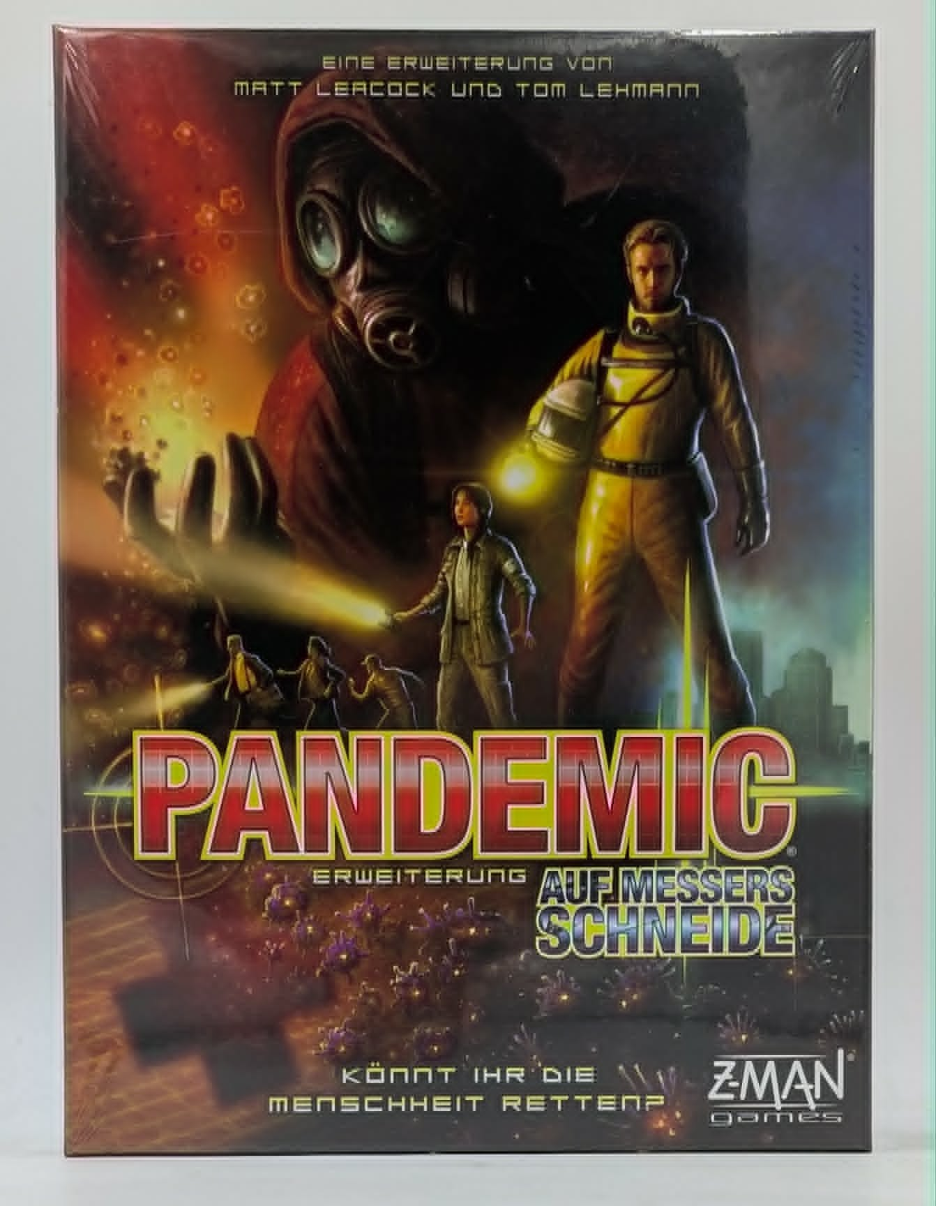 Pandemic-Spielschachtel mit Charakteren in Schutzanzügen und einer riesigen Gasmaskenfigur im Hintergrund.