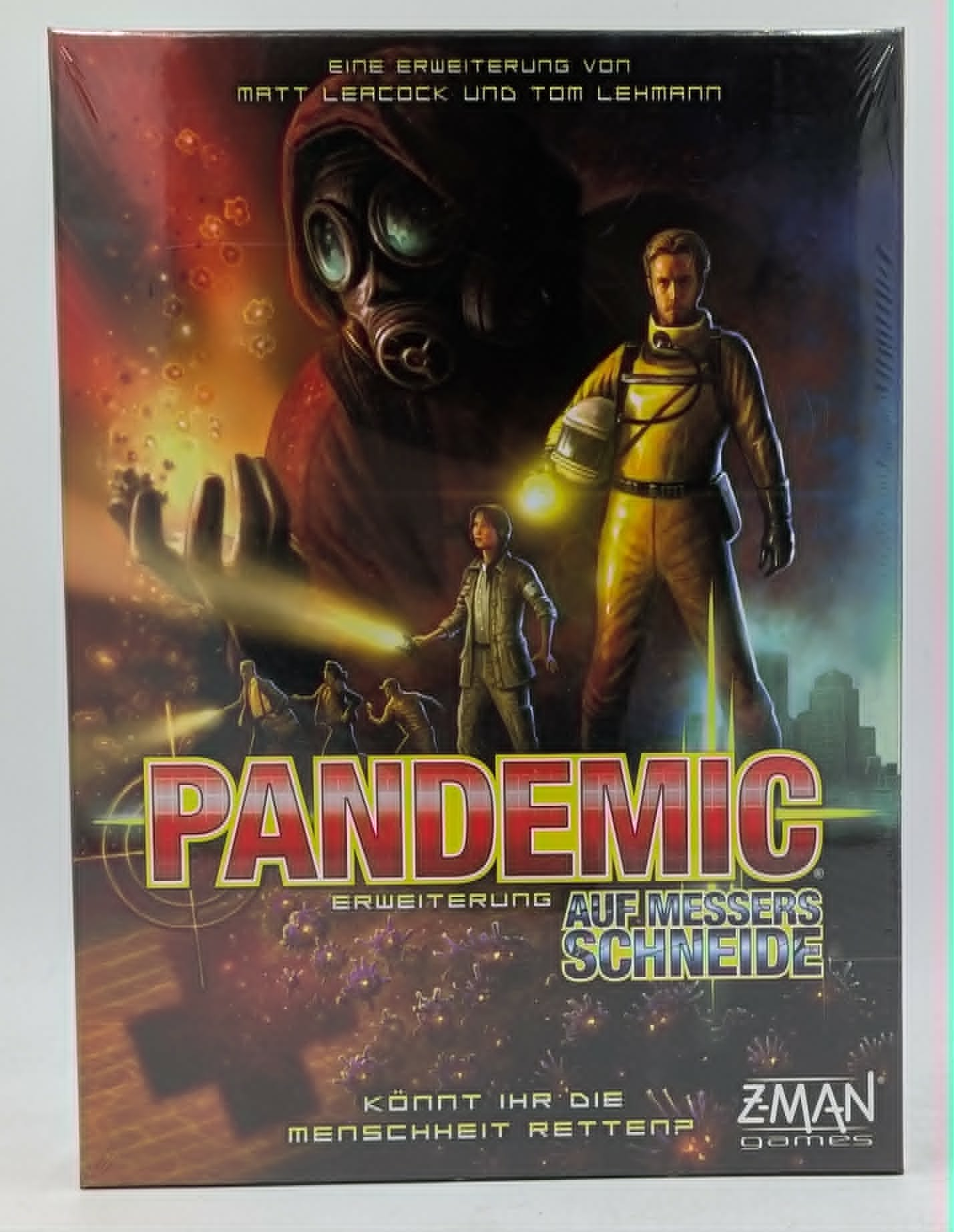 Brettspielbox Pandemic Auf Messers Schneide mit Charakteren in Schutzkleidung und Gasmaske.