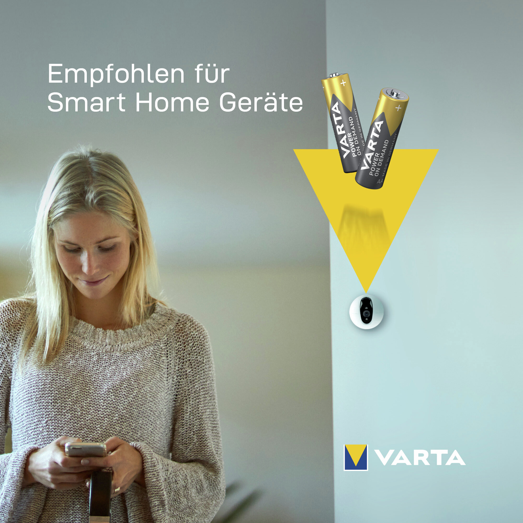 Eine lächelnde blonde Frau schaut auf ihr Handy, mit Varta-Batterien, einer Überwachungskamera und Text.