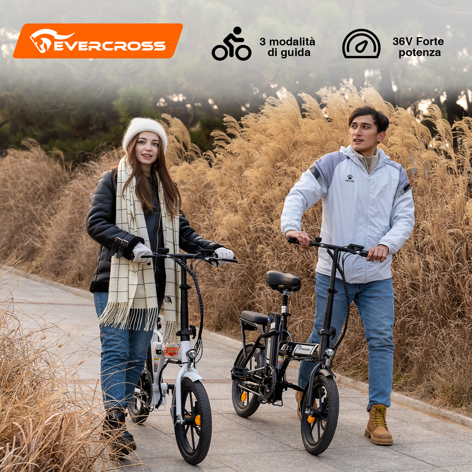 Un uomo e una donna posano con e-bike su un sentiero lastricato tra alte canne.