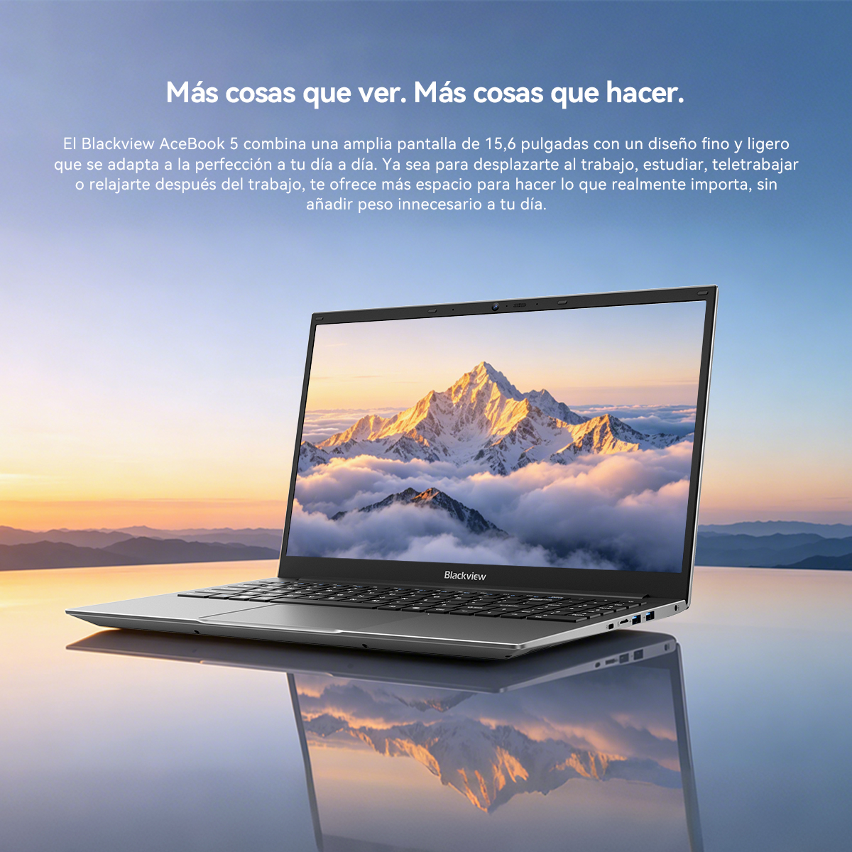 Un portátil plateado y elegante sobre una superficie reflectante ante un paisaje montañoso.