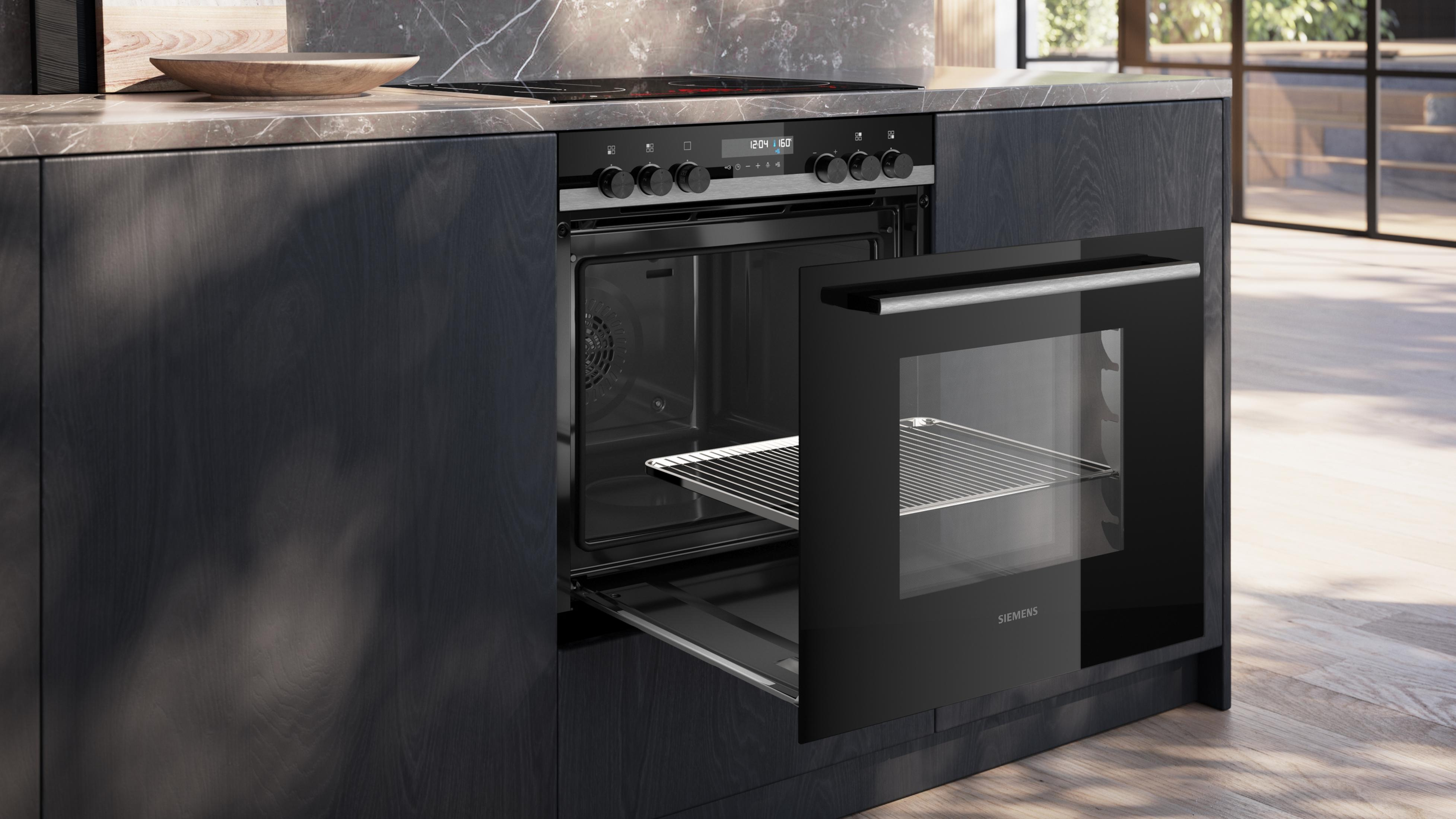 Moderne schwarze Einbaubackofen in dunkler Holzküche mit geöffneter Tür und einem Gitterrost.