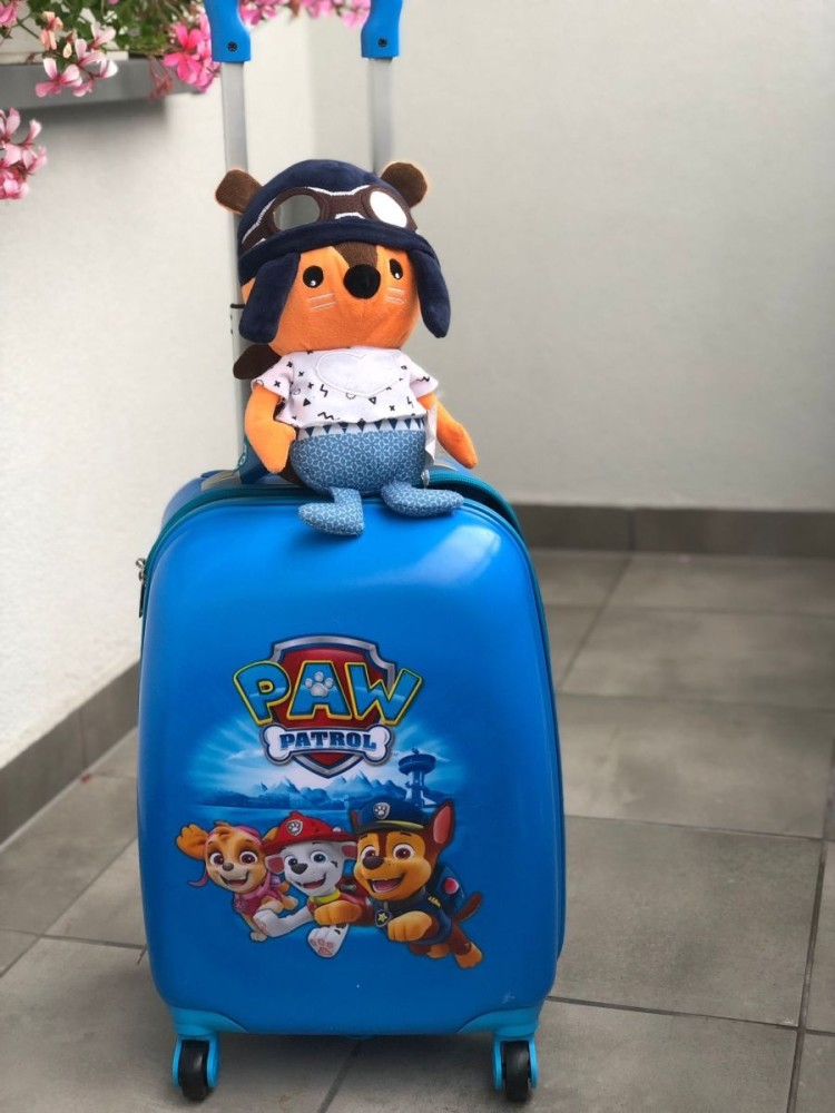 Niebieska walizka Paw Patrol z maskotką w czapce pilota na górze.
