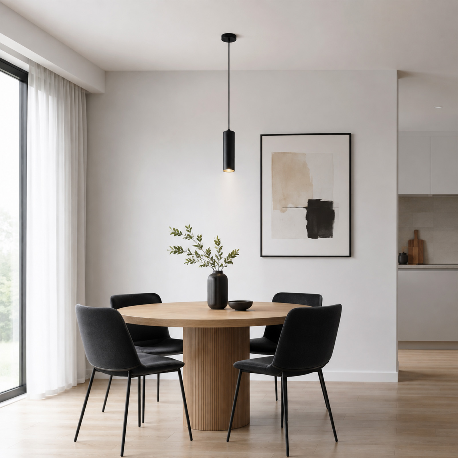 Mesa redonda de madera moderna con cuatro sillas negras, un florero y una lámpara colgante contra una pared blanca.