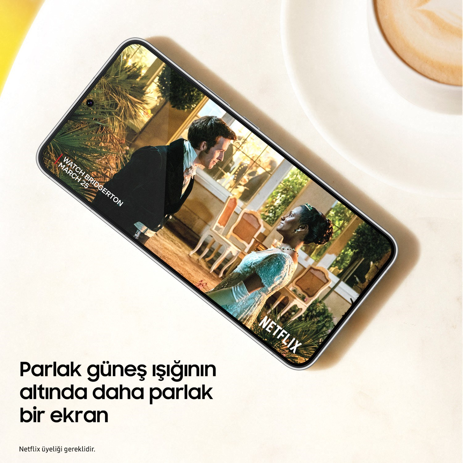 Bir akıllı telefon, bir fincan kahvenin yanında dönem kıyafetli iki kişiyi gösteren bir Netflix sahnesi oynatıyor.