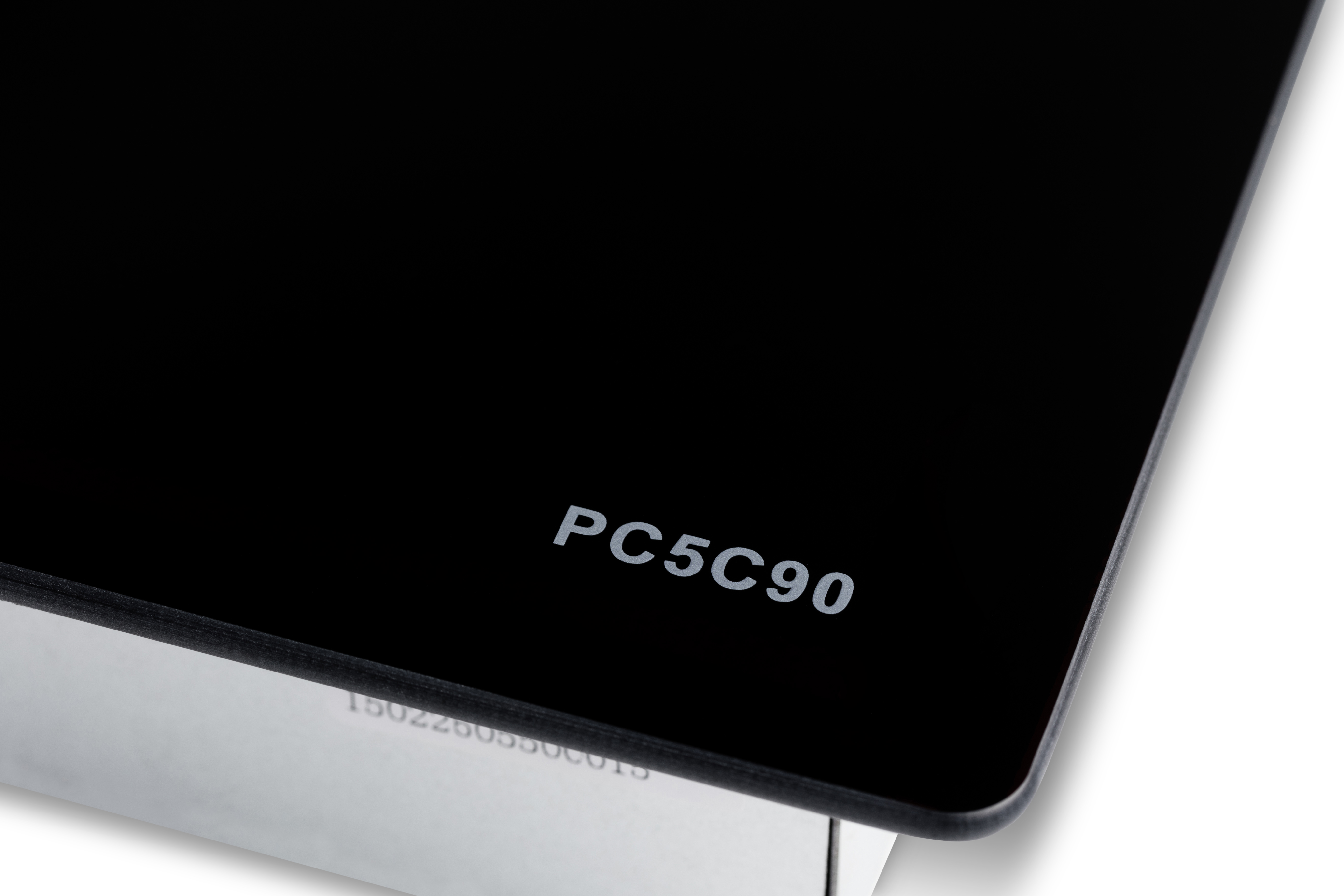 Superficie nera lucida con testo bianco PC5C90 nell'angolo, sopra una sezione argentata.