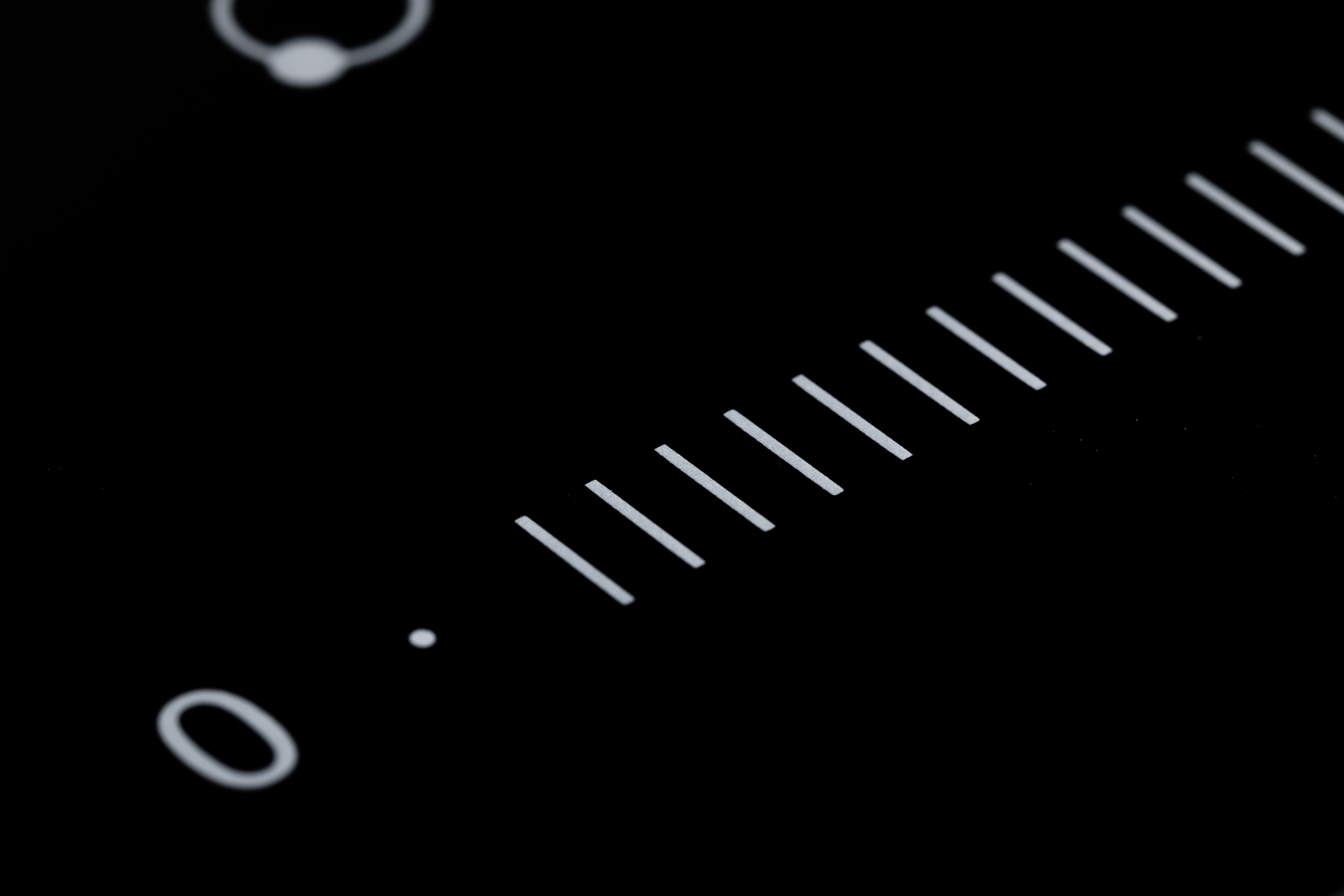 Un piano cottura nero con una scala bianca che parte da zero e linee diagonali.