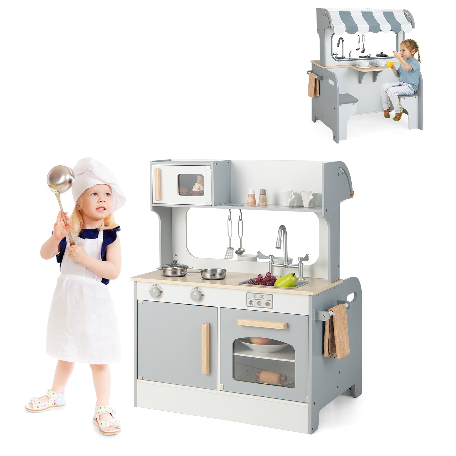 Un tout-petit en toque et tablier tient une louche près d'une cuisine jouet grise et blanche.