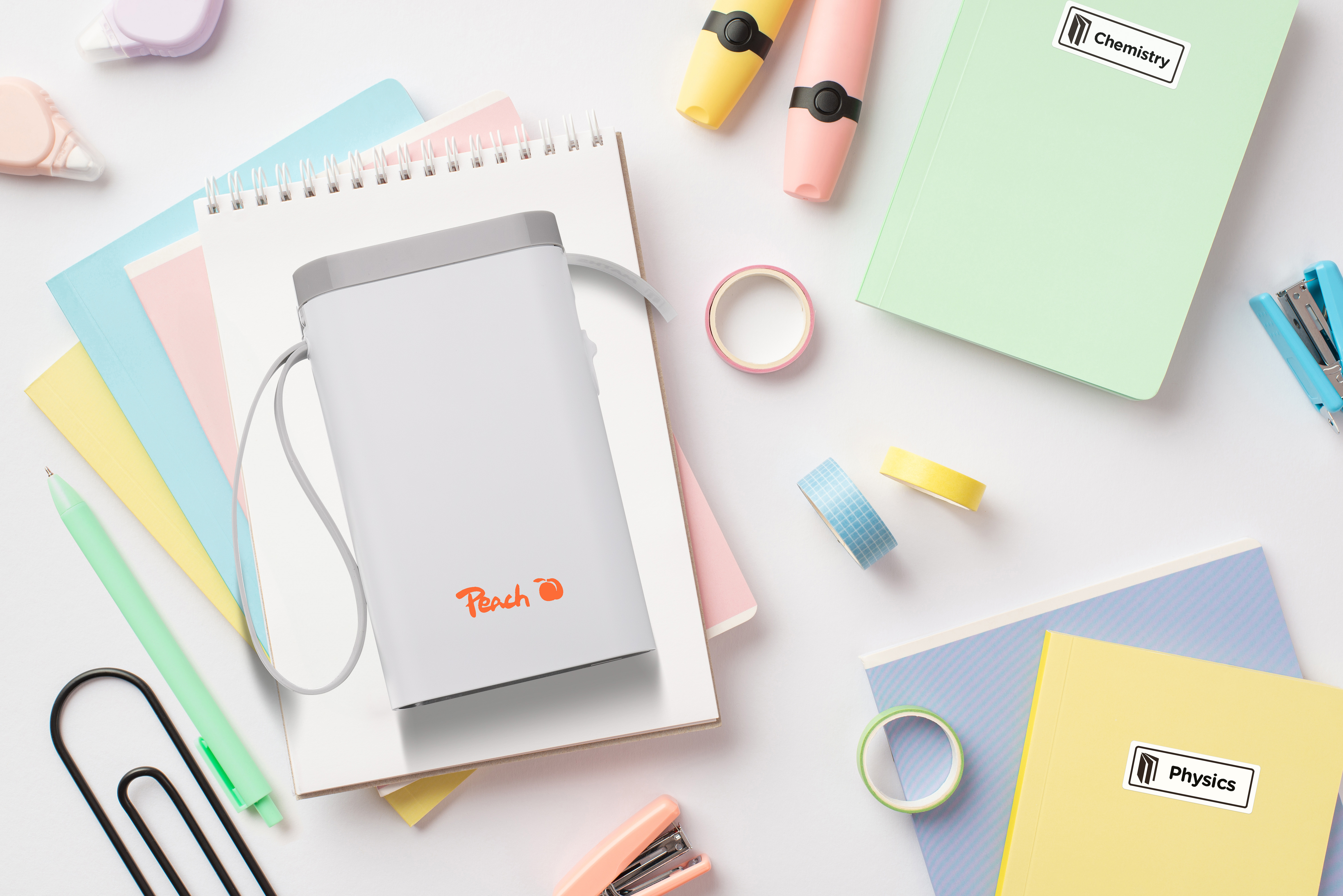 Une vue aérienne de fournitures scolaires colorées, de cahiers, de stylos et d'une trousse Peach sur fond blanc.