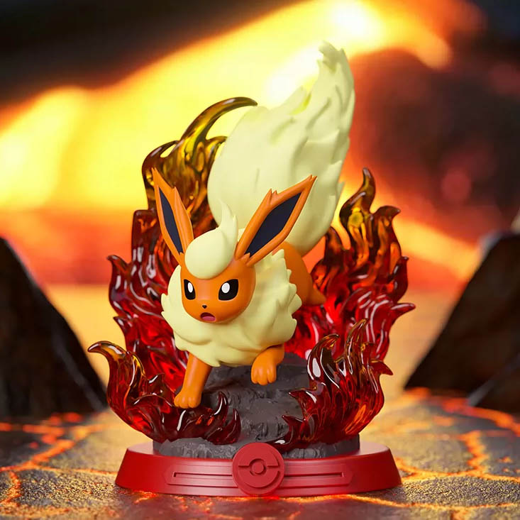 Eine Flareon-Figur steht auf einem felsigen Sockel, umgeben von durchscheinenden roten Flammen vor feurigem Hintergrund.