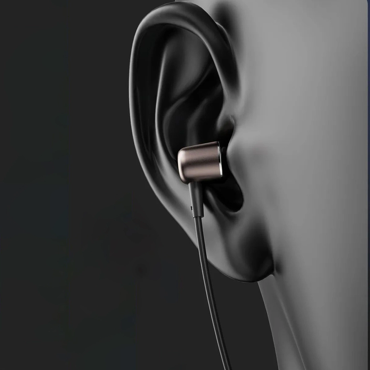 Un auricolare in-ear grigio nell'orecchio di un manichino nero su sfondo scuro.