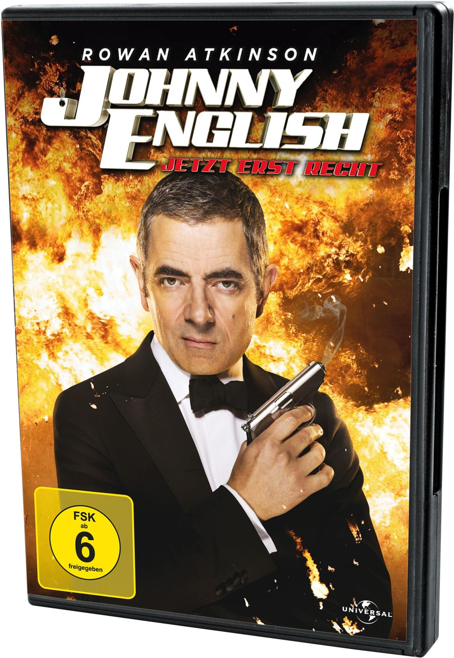 Rowan Atkinson hält einen rauchenden Revolver vor einer Explosion auf dem Johnny English DVD-Cover.