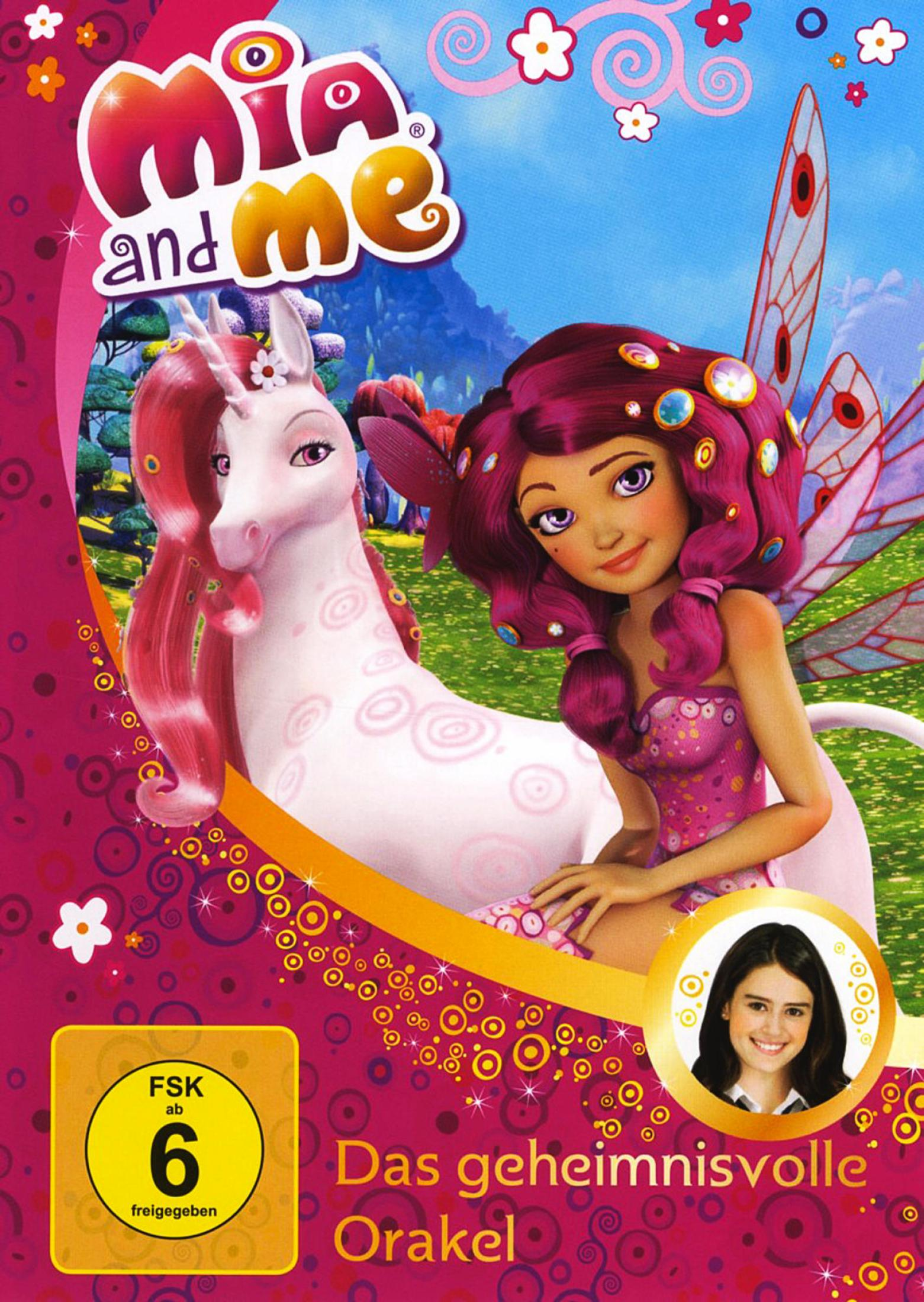 Mia mit pinken Haaren und Flügeln sitzt neben einem weißen Einhorn auf einer farbenfrohen Wiese.