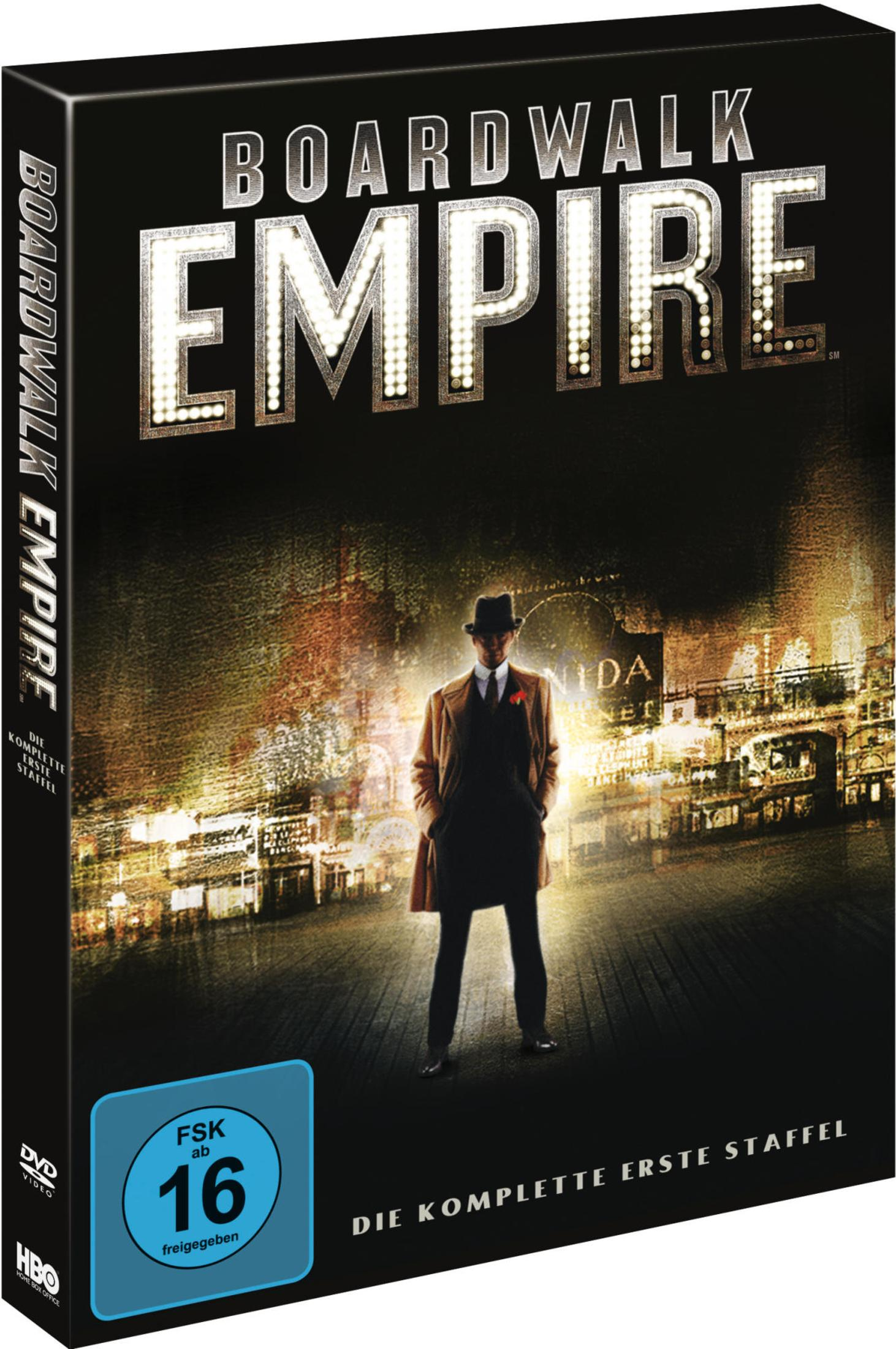 DVD-Cover von Boardwalk Empire mit einem Mann im Mantel und Hut vor einer beleuchteten Stadtkulisse.
