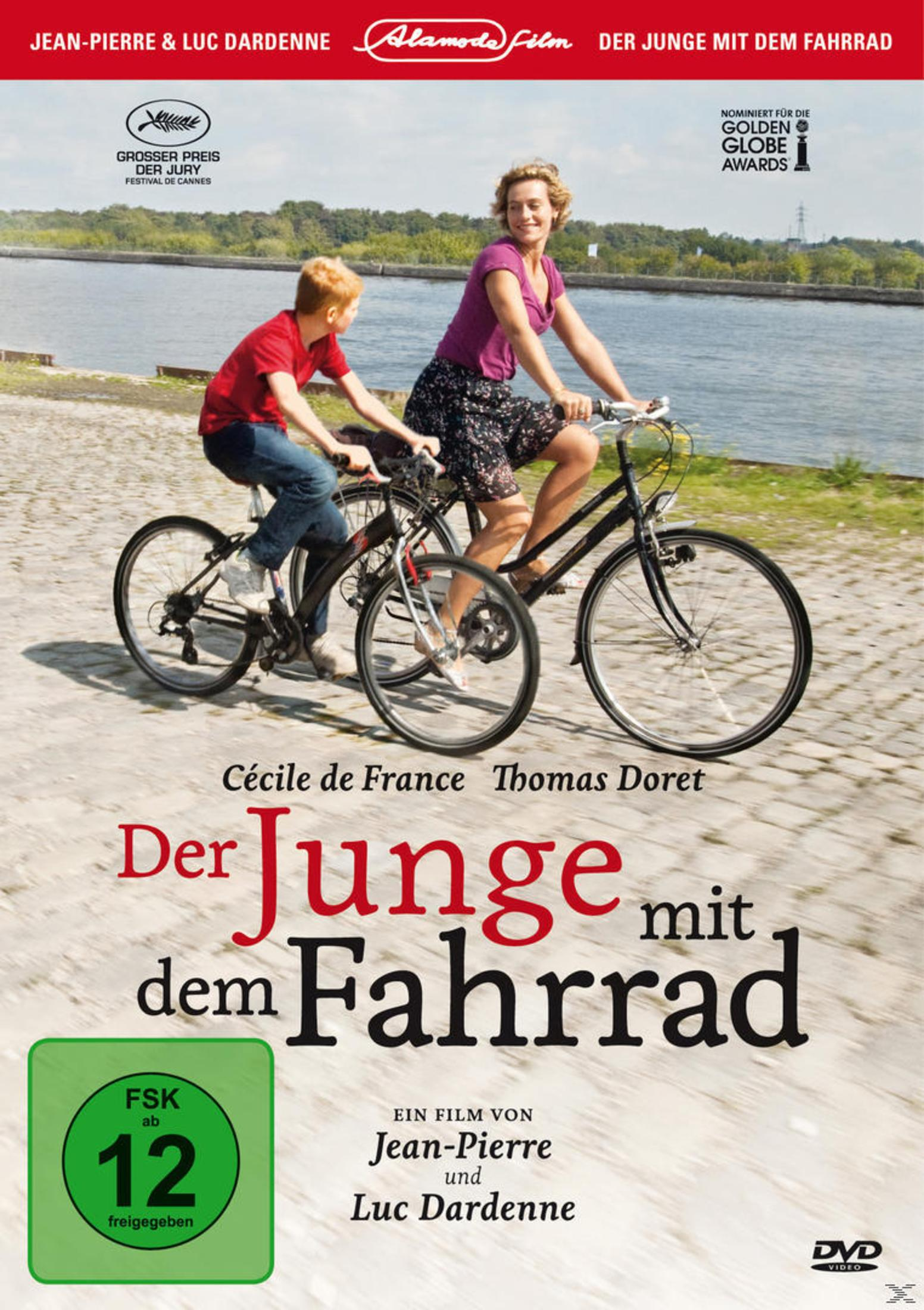 Eine Frau und ein Junge fahren nebeneinander auf Fahrrädern an einem Flussufer.
