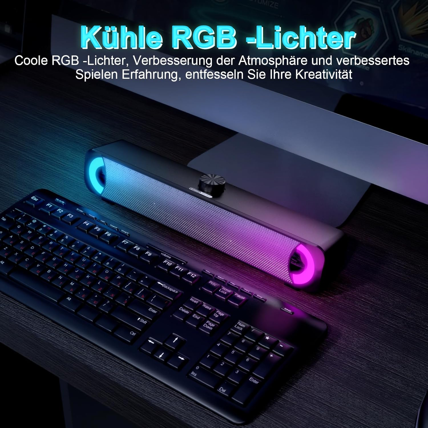 Eine schwarze Soundbar mit bunten RGB-Leuchten steht vor einer Tastatur und einem Monitor auf einem Schreibtisch.