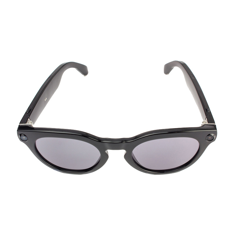 Occhiali smart neri con lenti scure e telecamere integrate sulla montatura su sfondo bianco.