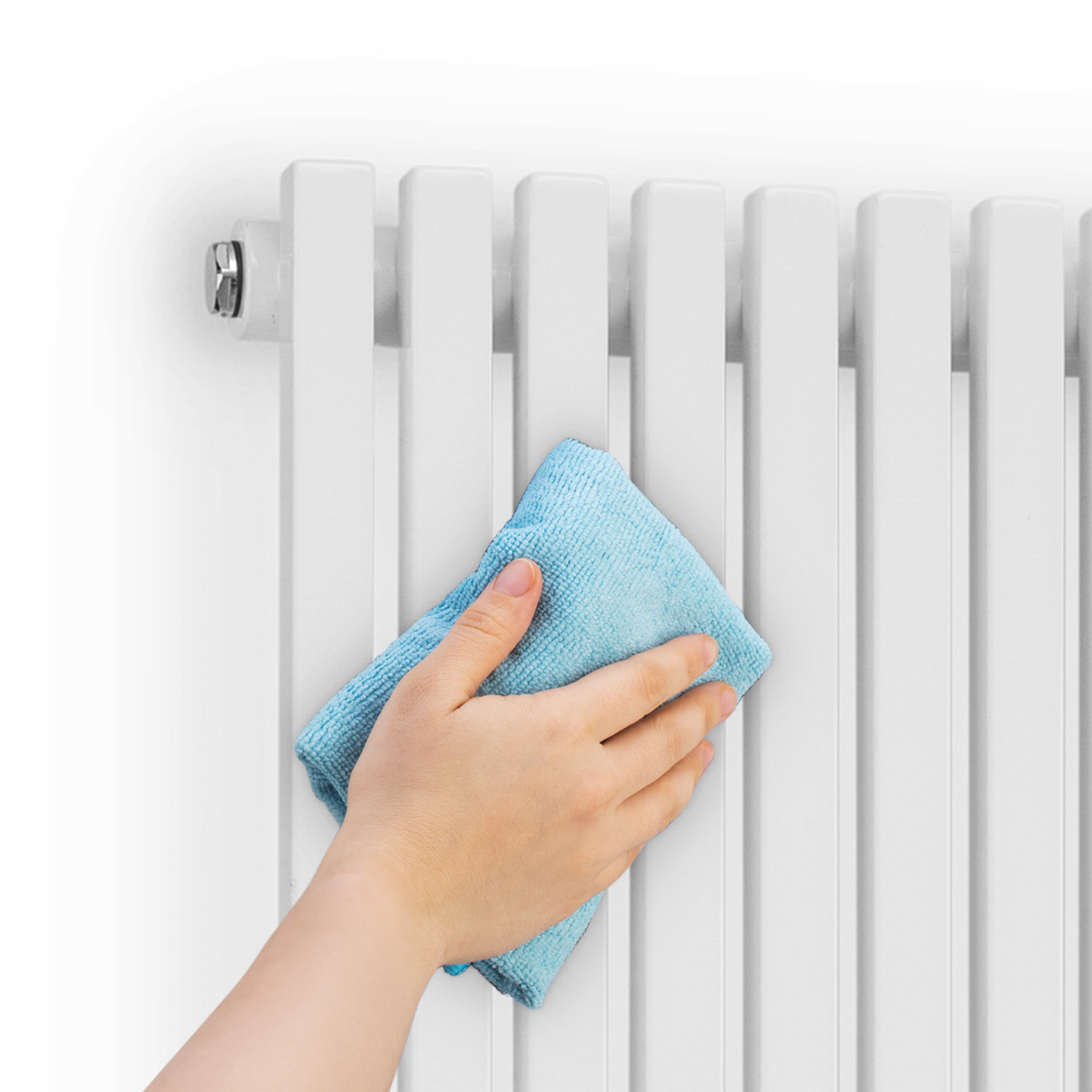 Una mano pulisce un termosifone bianco con un panno in microfibra blu.
