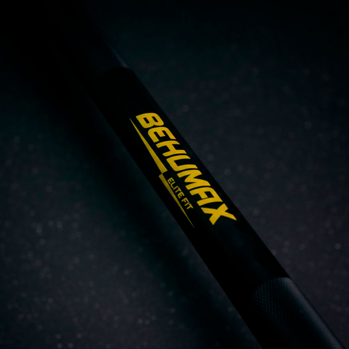 Una barra negra con el logotipo amarillo de Behumax Elite Fit sobre fondo oscuro.