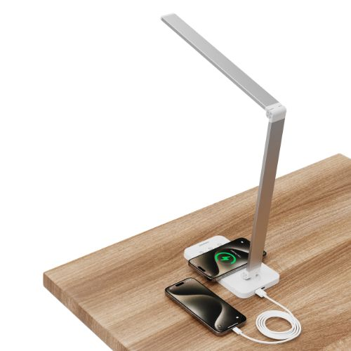 Moderne LED-Schreibtischlampe in Silber auf Holzpult, zwei Smartphones werden geladen.