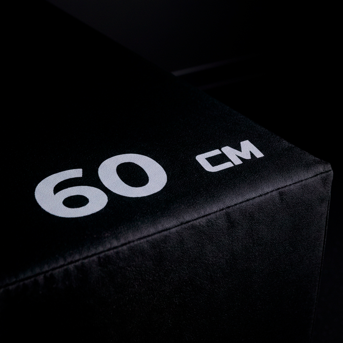 Una caja pliométrica negra con el texto blanco 60 CM impreso en la superficie superior.