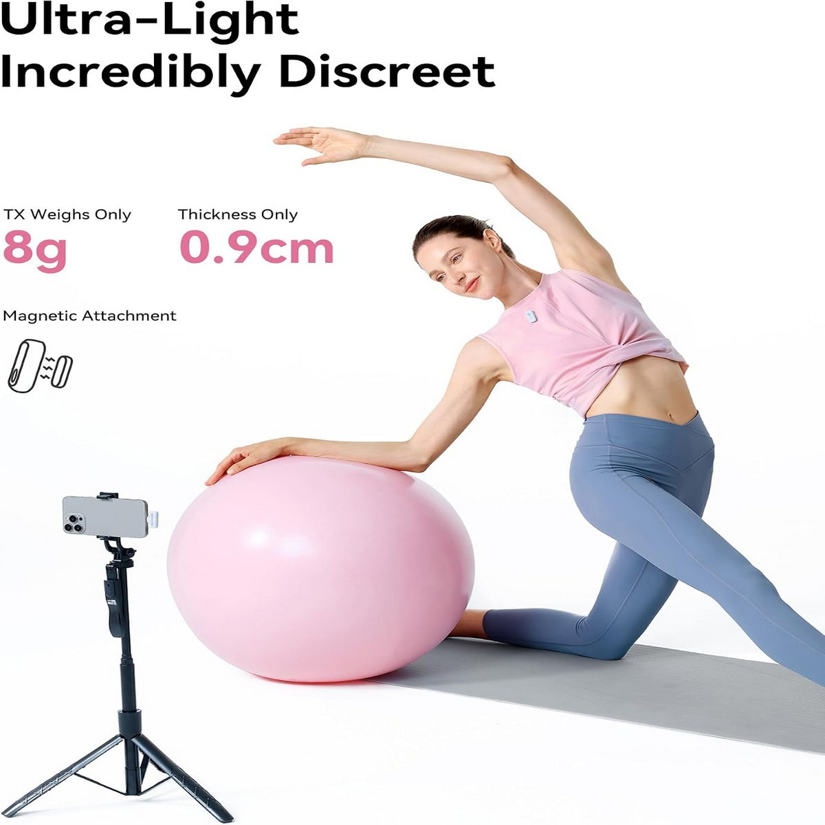 Eine Frau in Sportkleidung macht Yoga neben einem Smartphone auf einem Stativ und einem rosa Gymnastikball.