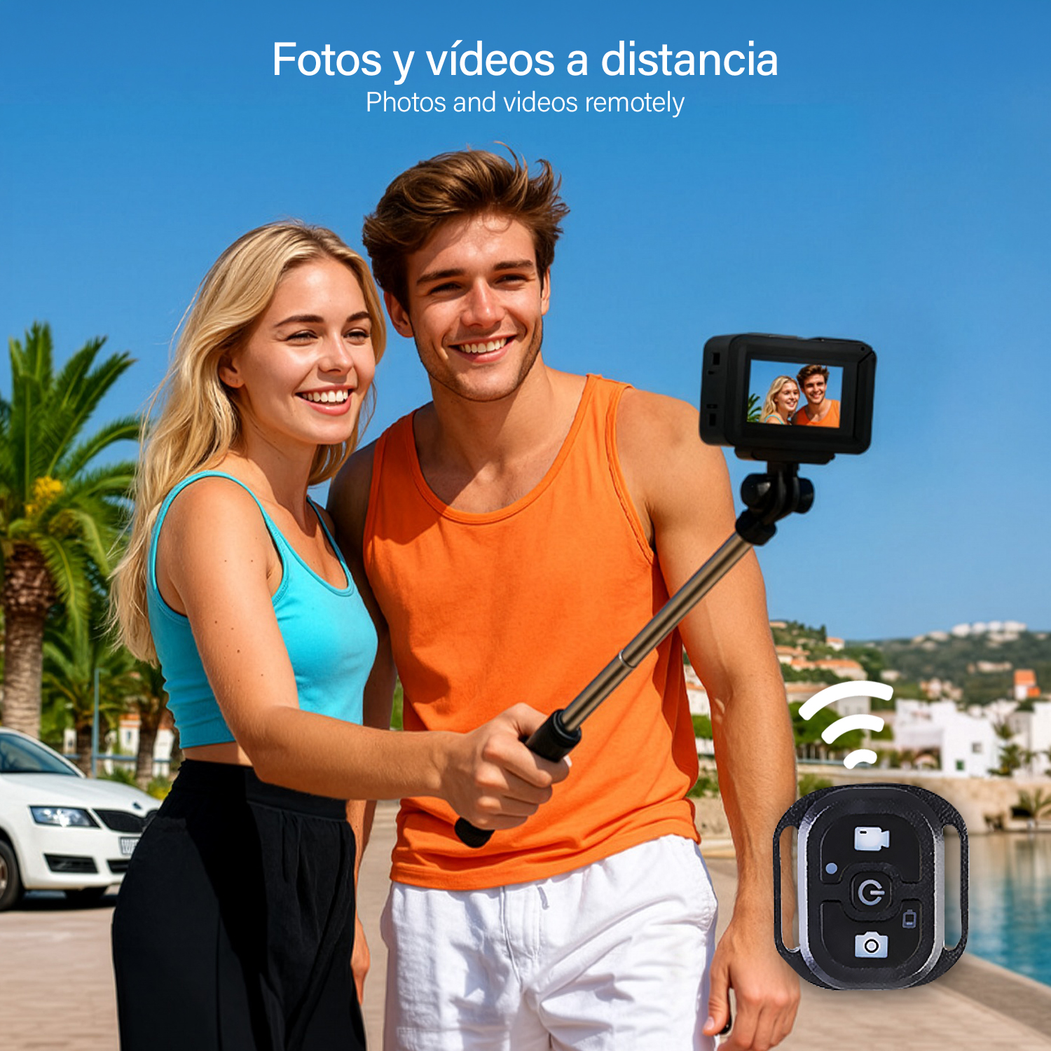 Pareja tomándose una foto con un control remoto y un palo selfie frente a un paisaje costero azul.