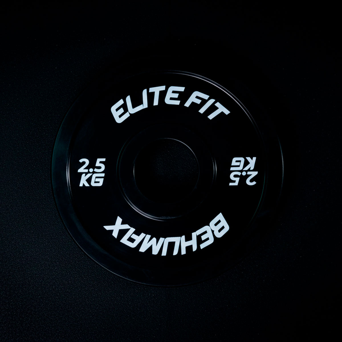 Un disco de pesa Elite Fit de 2.5 kg en un fondo oscuro.