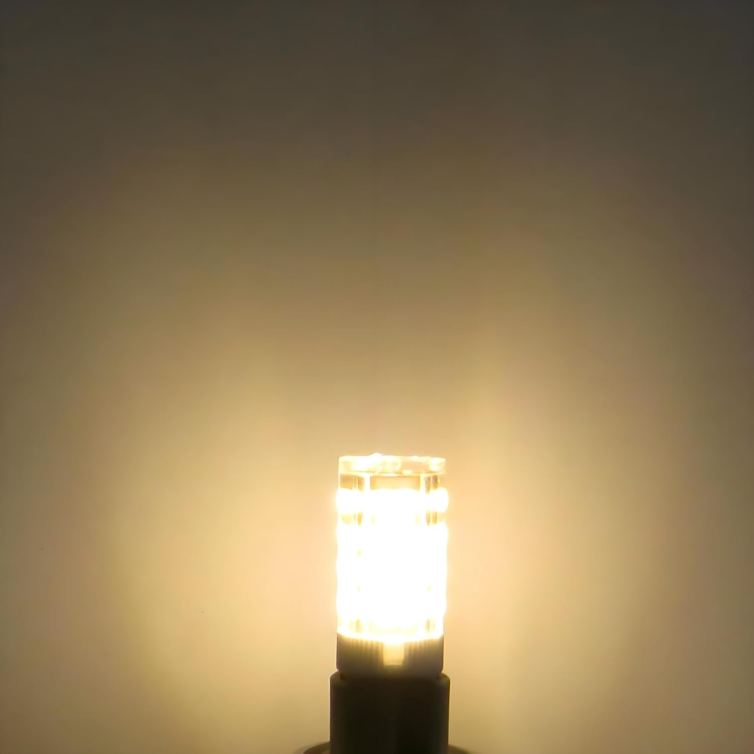 Eine kleine LED-Glühbirne leuchtet warm gelb vor einem dunklen Hintergrund.