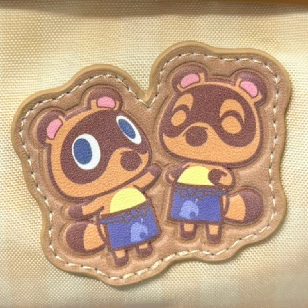 Un parche de cuero marrón muestra dos simpáticos mapaches de dibujos animados con delantales azules.