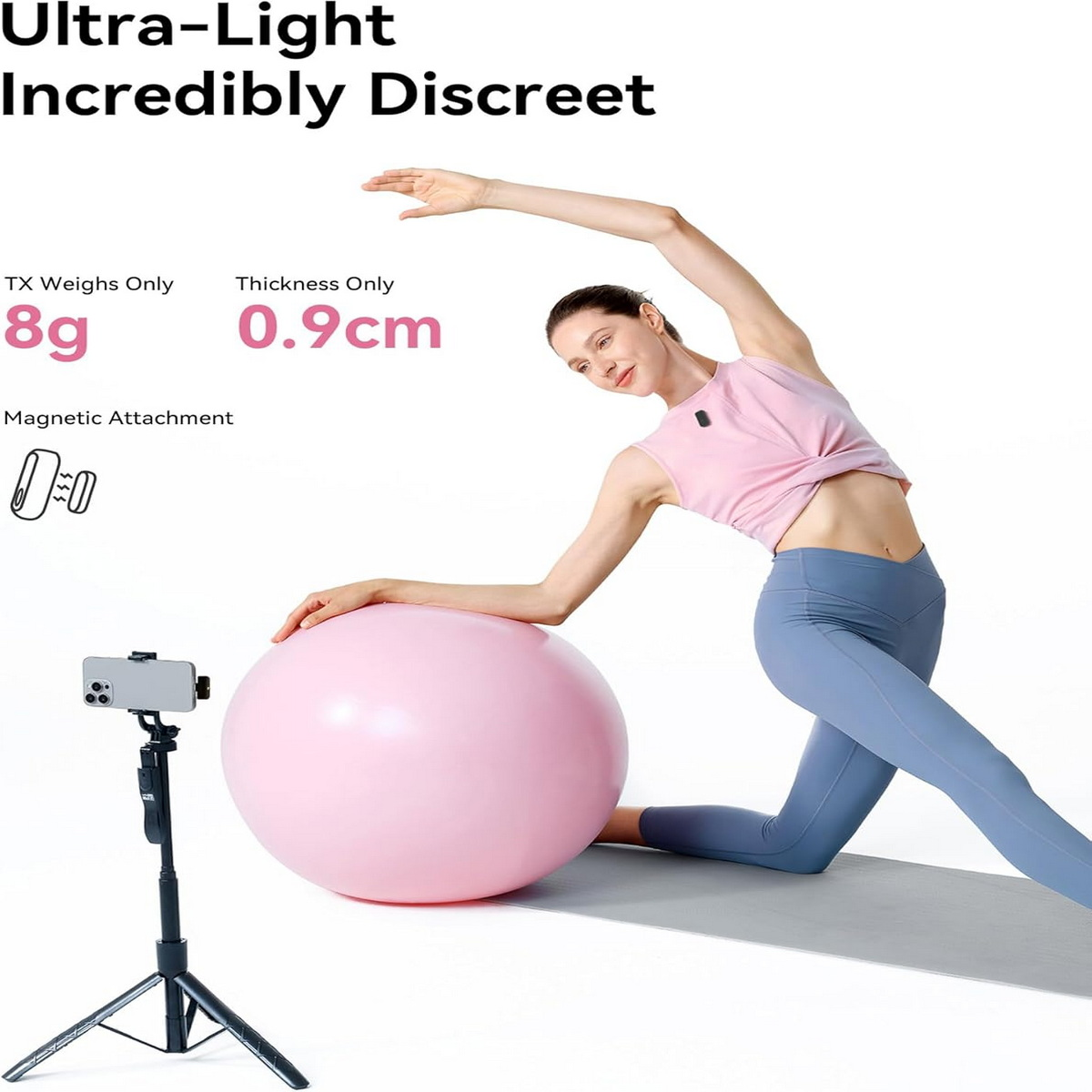 Eine Frau in pinkem Top und blauen Leggings dehnt sich mit einem pinken Yogaball, gefilmt von einem Smartphone auf Stativ.