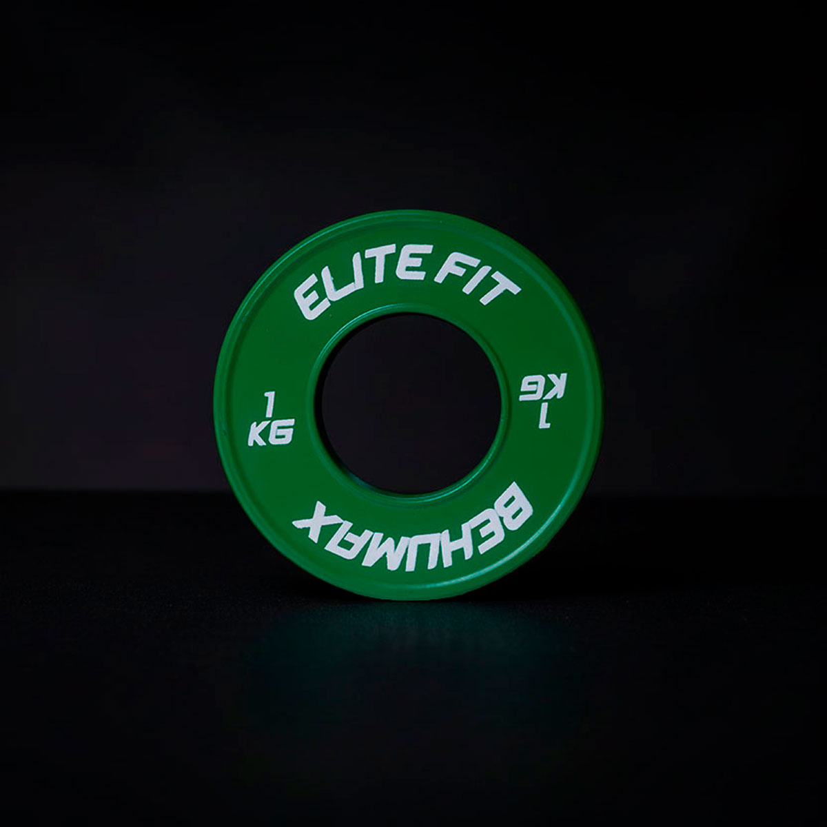 Un disco de pesas verde Elite Fit de 1 kg sobre una superficie oscura.