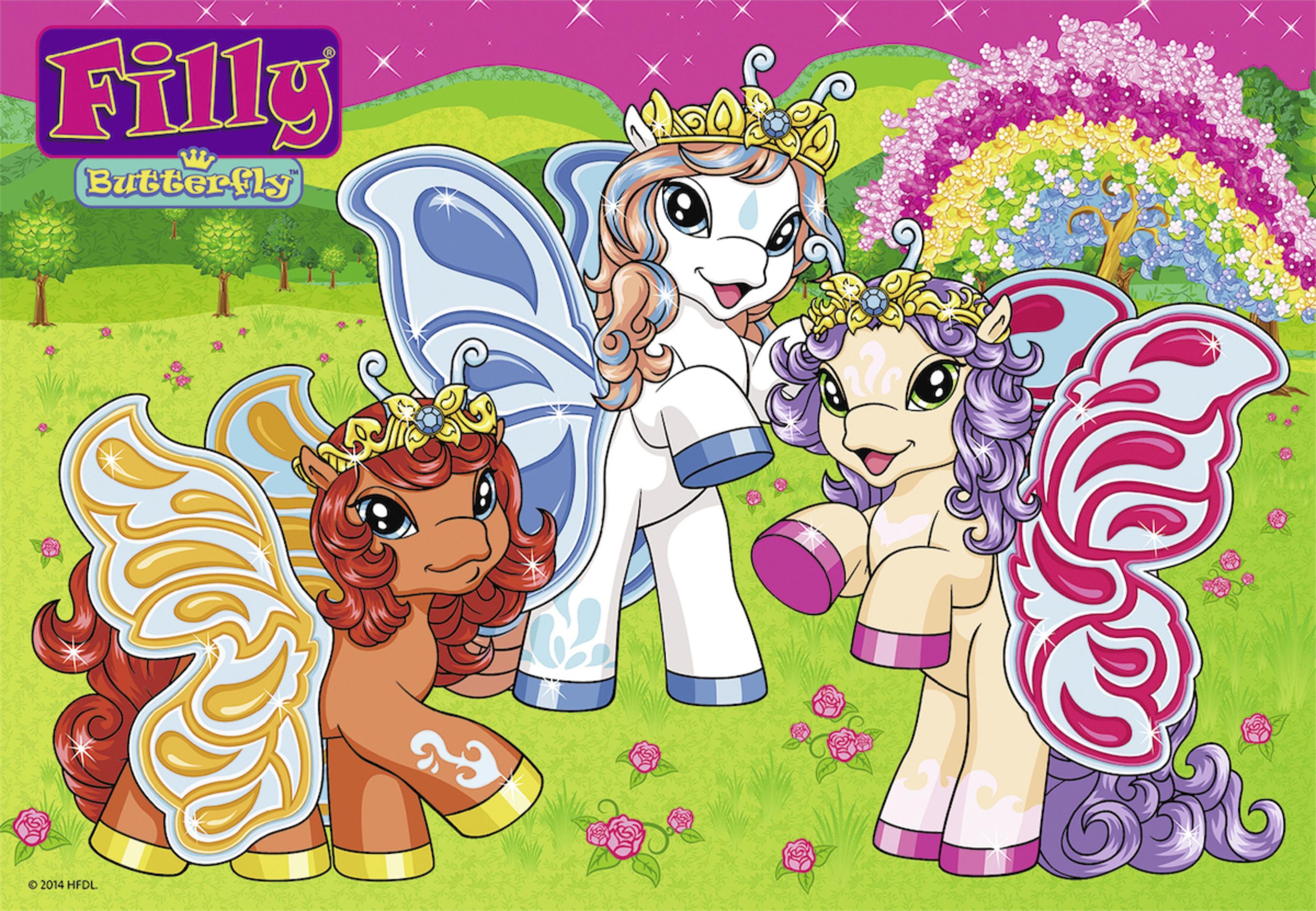 Drei Filly Butterfly Ponies mit Kronen und Feenflügeln auf einer blühenden Wiese mit Bäumen und Regenbogen.