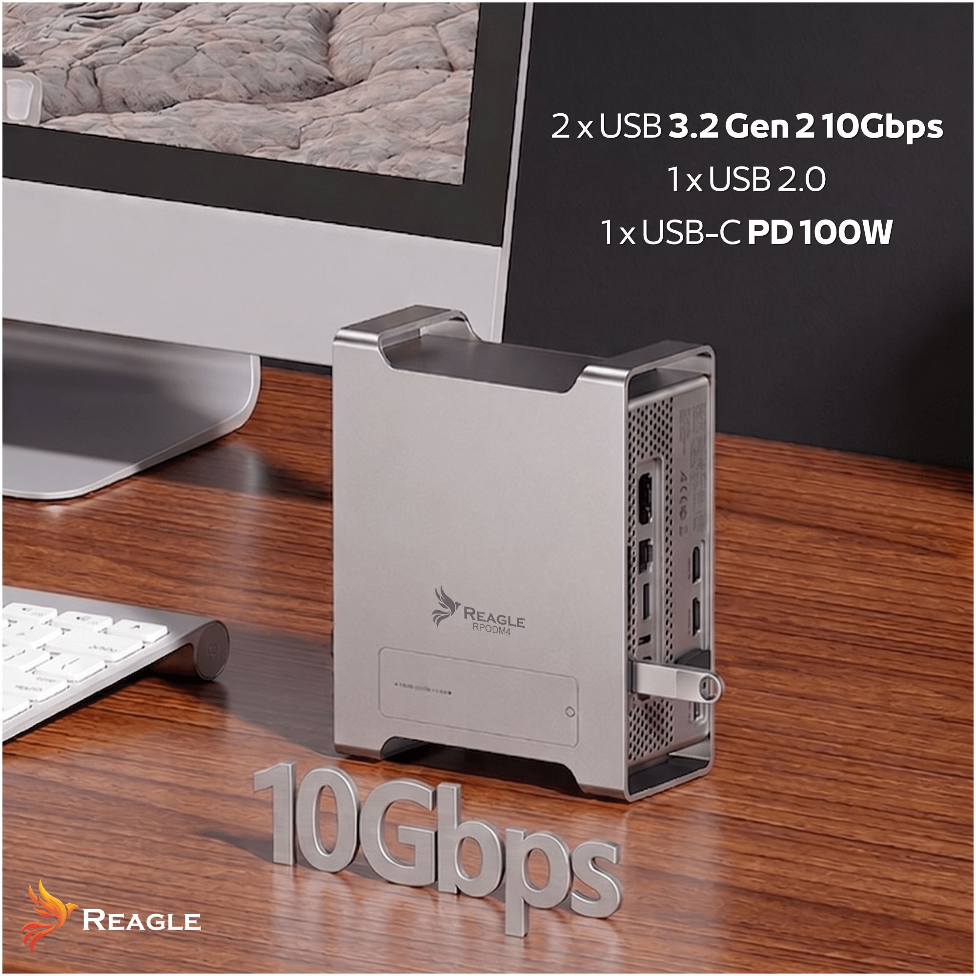 Silberner Reagle RPODM4 Hub auf einem Holztisch mit Monitor, Tastatur und "10Gbps" Schriftzug.