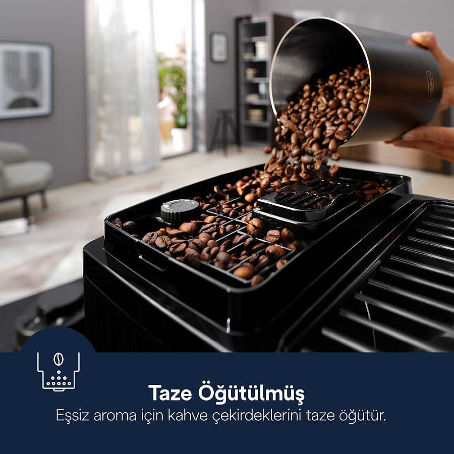 Kahve çekirdekleri bir kapta kahve makinesinin haznesine dökülüyor.