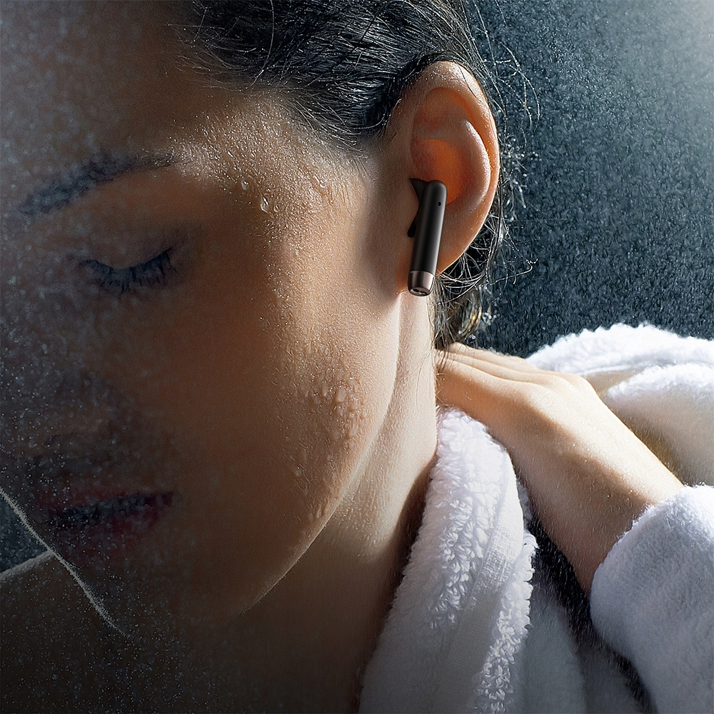 Una donna in accappatoio bianco fa la doccia, con acqua che le spruzza sul viso, indossando un auricolare nero.