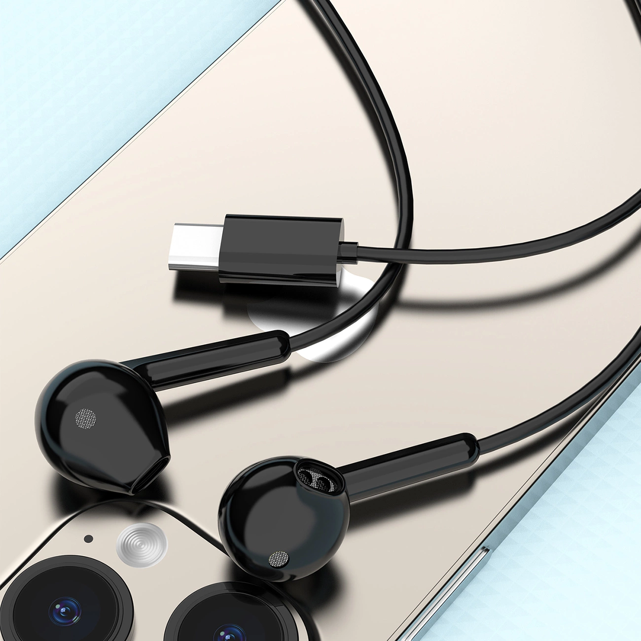 Cuffie nere con connettore Type-C su uno smartphone dorato.