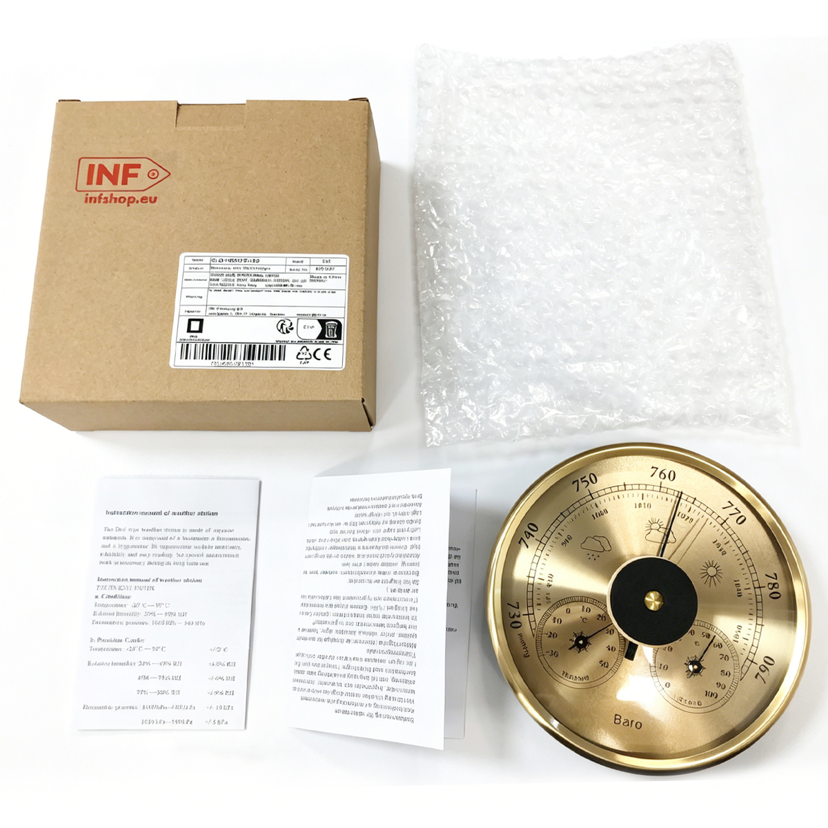 Goldenes Barometer mit Karton, Blasebalgfolie und Anleitung auf weißem Tisch.