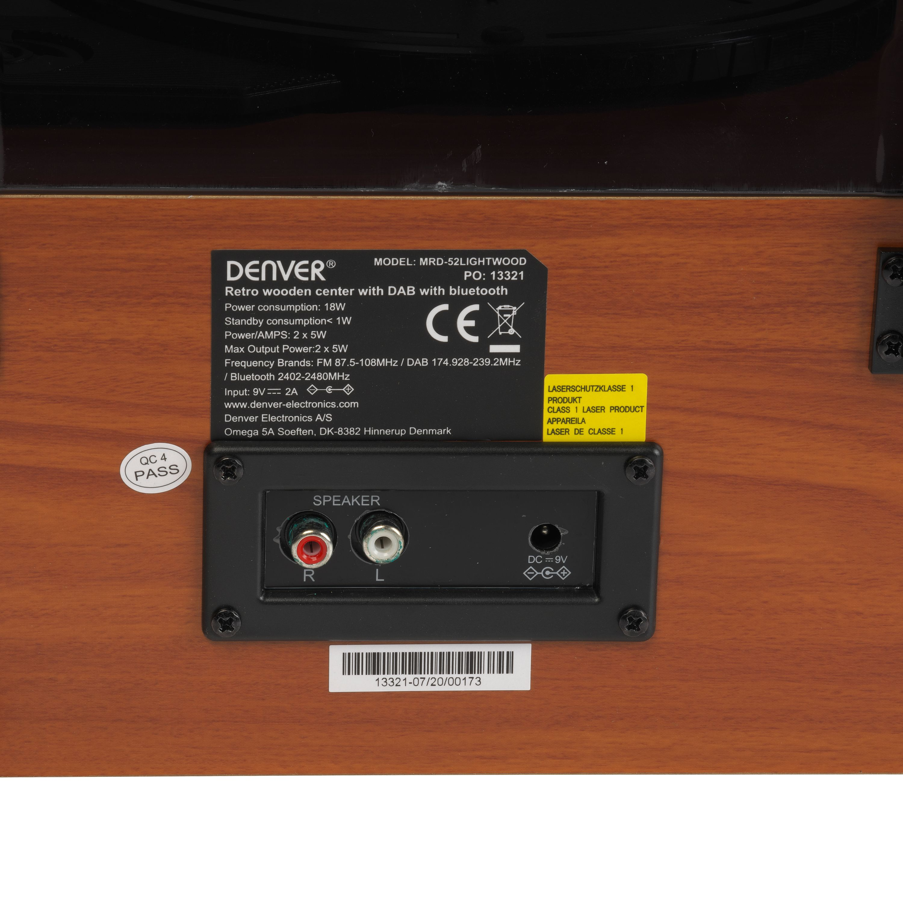 Il pannello posteriore di un dispositivo audio in legno mostra terminali per altoparlanti ed etichette.