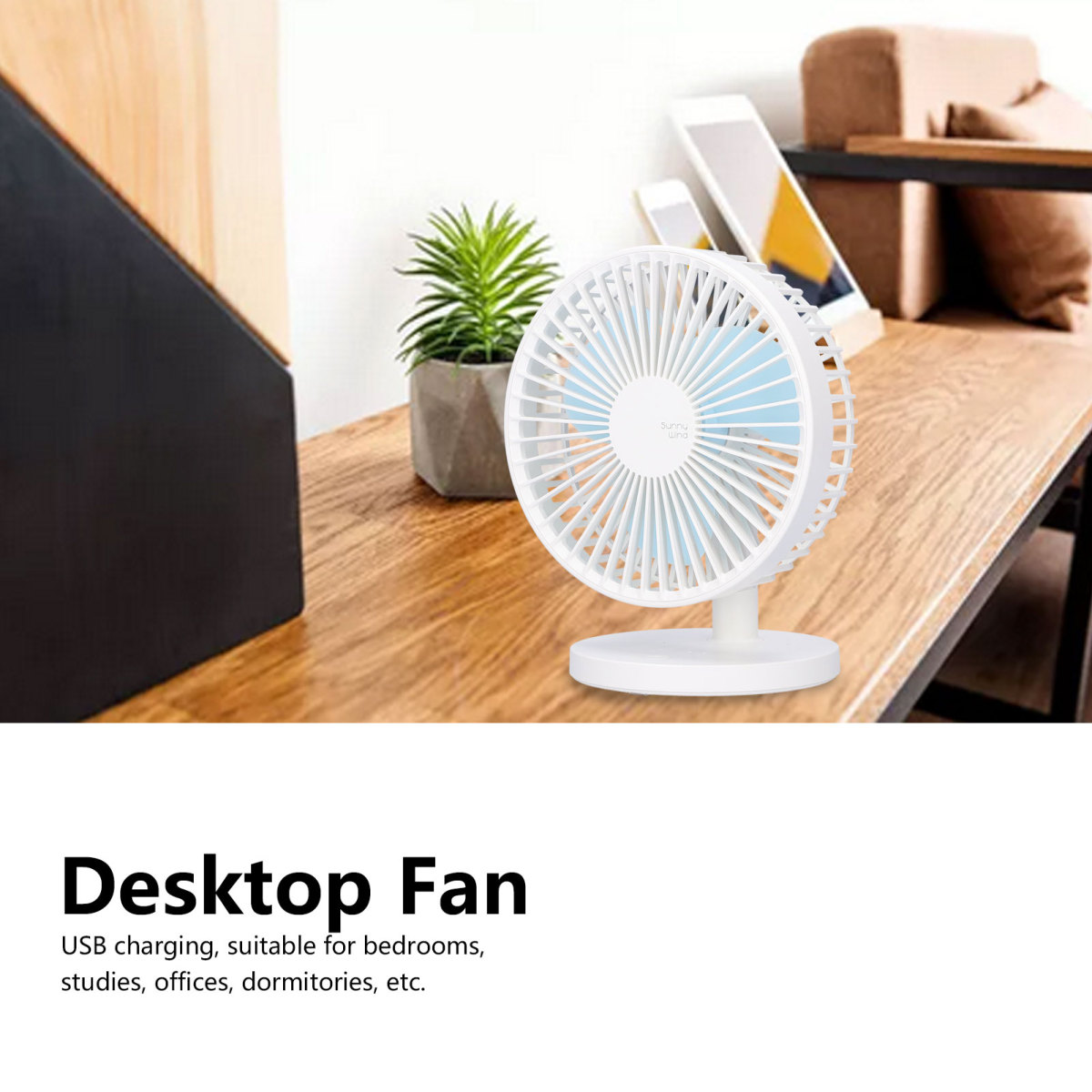Kleiner weißer Tischventilator mit blauen Flügeln auf einem Holzschreibtisch, dahinter eine Pflanze und ein Tablet.