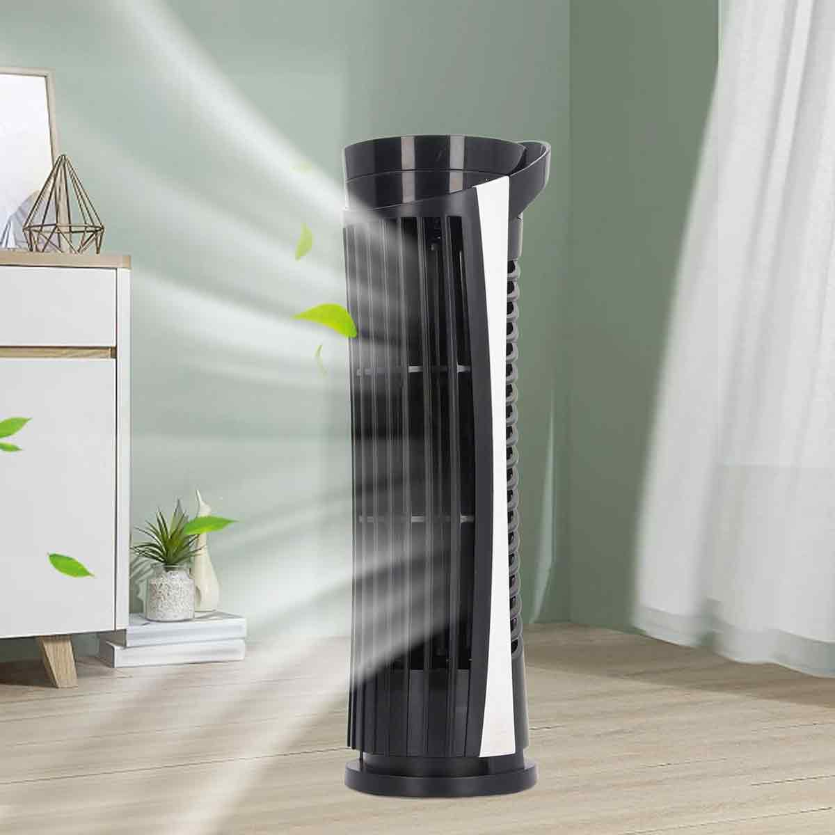 Ein schwarzer Turmventilator bläst Luft in einem Raum, grüne Blätter schweben in den Windstreifen.