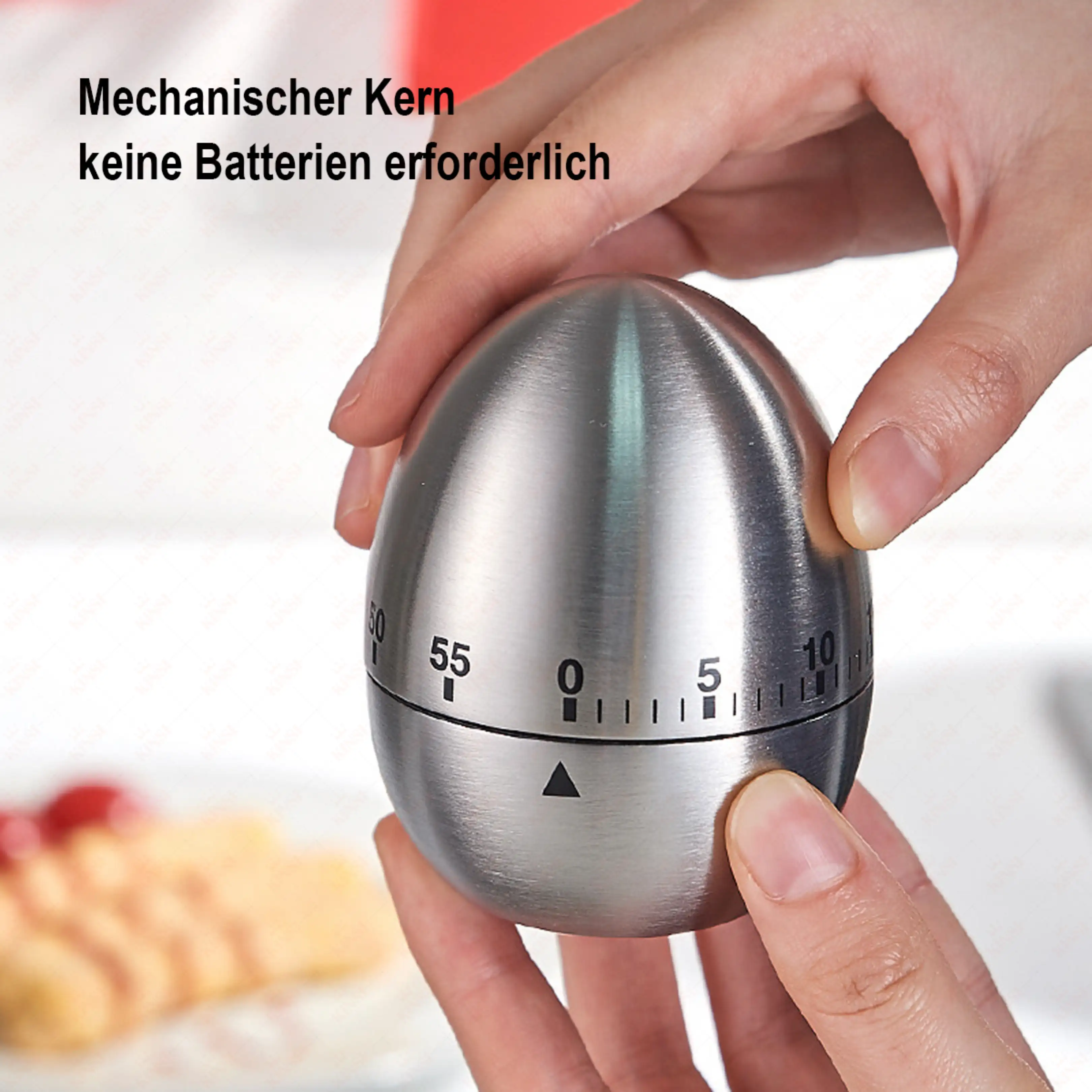 Hände halten einen silbernen, eiartigen Küchen-Timer mit Zahlen und Skala.