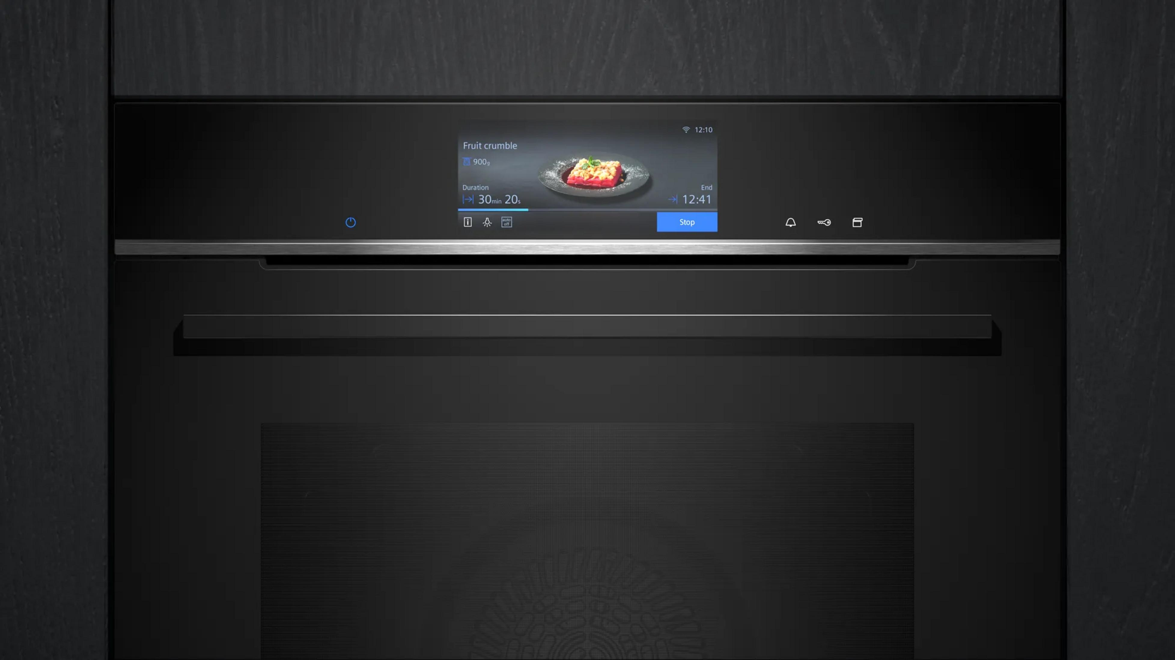 Micro-ondes encastrable noir moderne avec écran numérique affichant un crumble aux fruits.