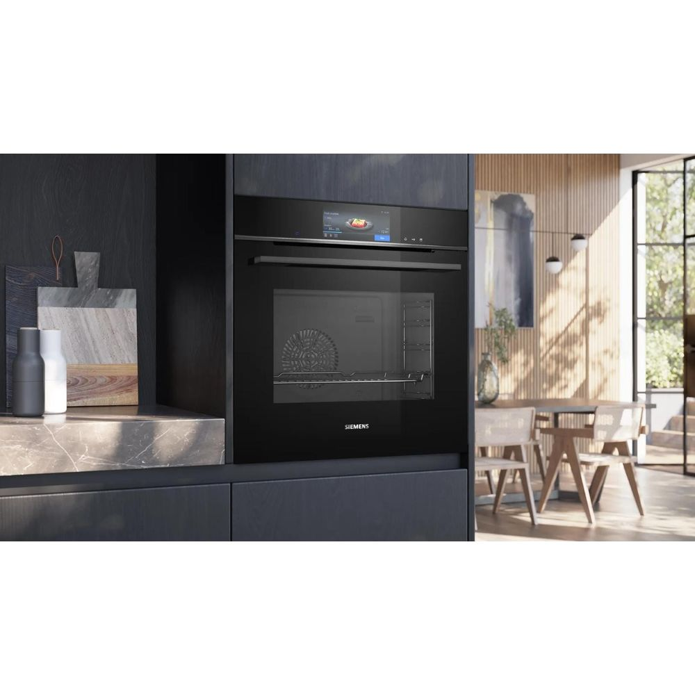 Four encastrable Siemens noir moderne dans une cuisine en bois élégante, coin repas en arrière-plan.
