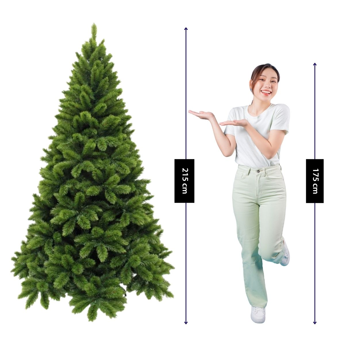Une femme en chemise blanche et pantalon clair désigne un grand sapin de Noël artificiel de 215 cm.
