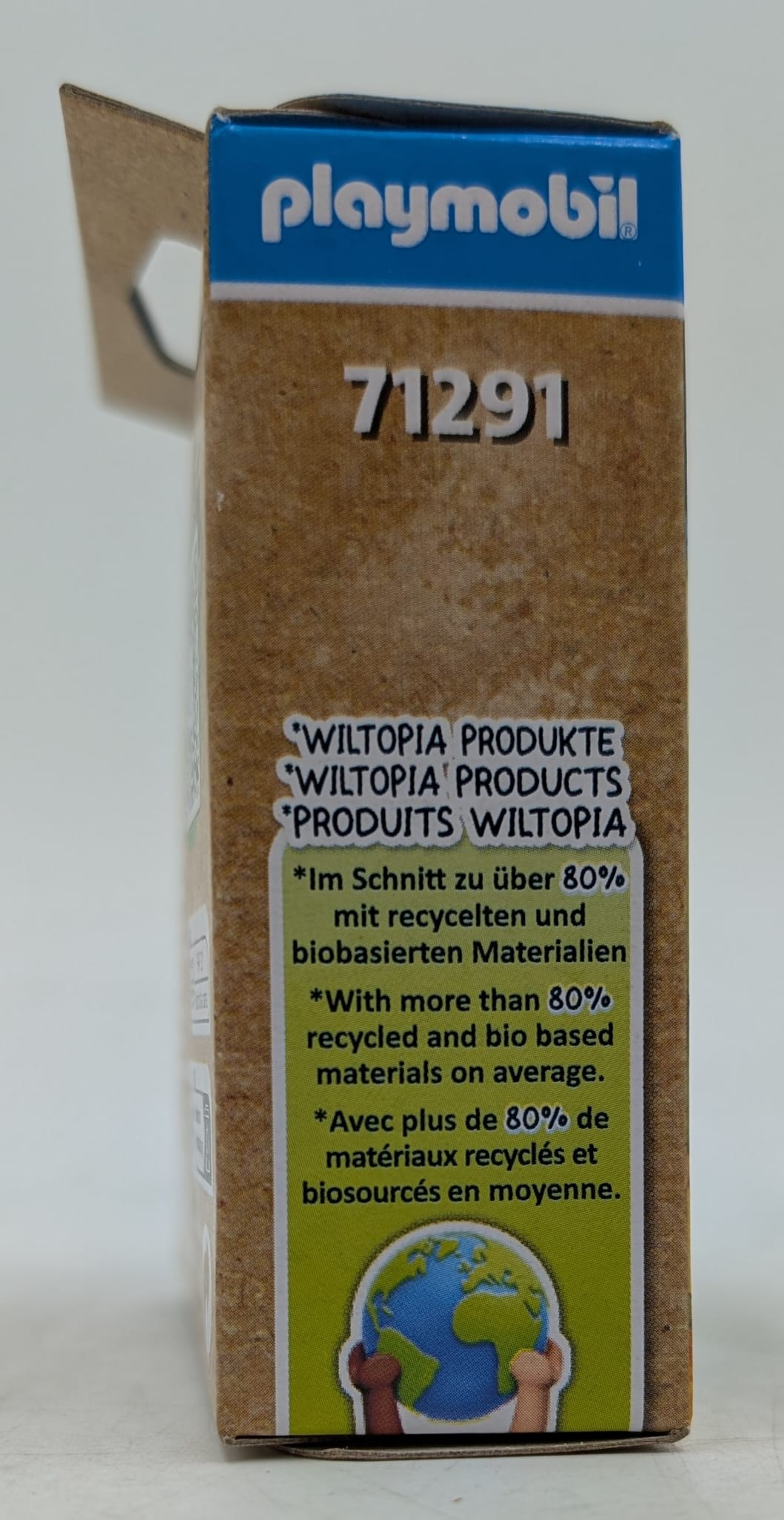 Playmobil Wiltopia Verpackungseite mit Text zu recycelten Materialien und Erdgrafik.