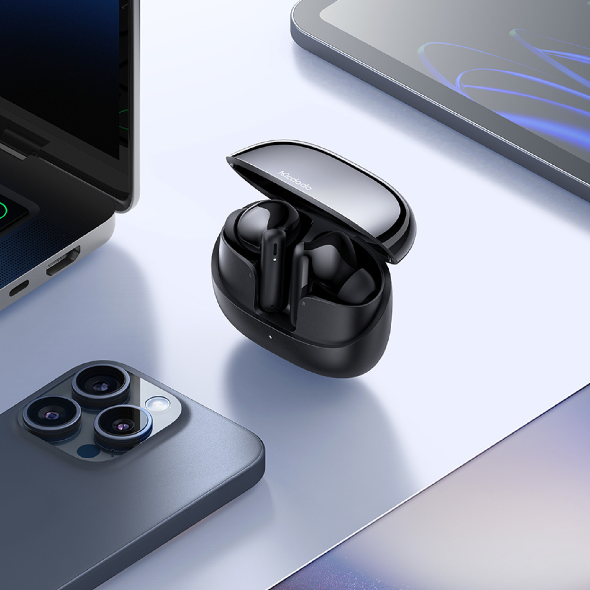 Auricolari wireless neri in una custodia di ricarica tra un laptop, uno smartphone e un tablet.